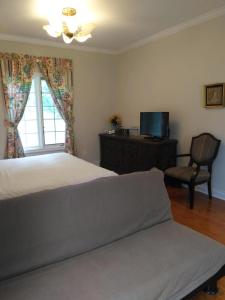 1 dormitorio con cama, ventana y silla en Lake view resort style suite big room, en Tottenham