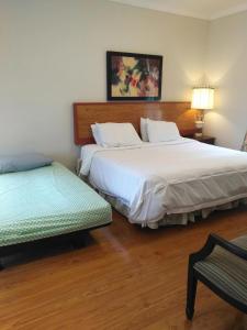 ein Schlafzimmer mit 2 Betten und einem Stuhl darin in der Unterkunft Lake view resort style suite big room in Tottenham