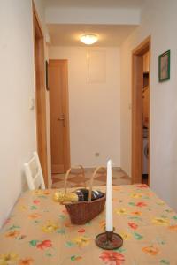 a table with a candle and a basket on it at Apartments with a swimming pool Mlini, Dubrovnik - 9009 in Mlini