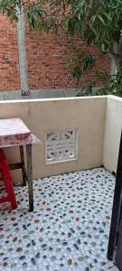 un patio con una mesa y una pared con una rejilla en Blue Beach Homestay, en Hoi An