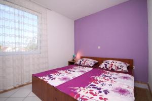 ein Schlafzimmer mit einem Bett mit lila Wänden und einem Fenster in der Unterkunft Apartments with a parking space Stari Grad, Hvar - 8752 in Stari Grad