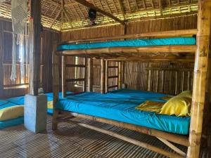 two bunk beds in a room with blue sheets at RUSTIQUE RUE Mabini - Hostel in Batangas City