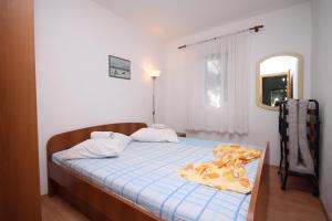 a bedroom with a bed with a blue blanket on it at Apartments by the sea Ivan Dolac, Hvar - 8782 in Ivan Dolac