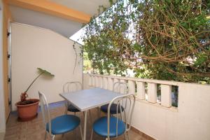 a table and chairs on a balcony with plants at Apartments by the sea Ivan Dolac, Hvar - 8782 in Ivan Dolac