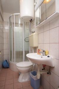 a bathroom with a toilet and a sink and a shower at Apartments with a parking space Hvar - 8810 in Hvar