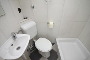 a white bathroom with a toilet and a sink at Apartments with a parking space Hvar - 8810 in Hvar