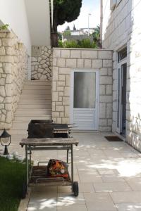 - un grill devant un bâtiment avec une porte dans l'établissement Apartments and rooms with parking space Mlini, Dubrovnik - 8994, à Mlini