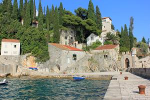 a group of buildings on a hill next to the water at Seaside holiday house Trsteno, Dubrovnik - 9017 in Zaton