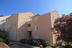 a row of apartment buildings with a flowering tree at Apartments with a parking space Cavtat, Dubrovnik - 9032 in Cavtat