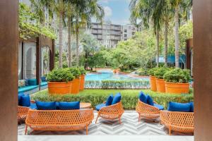 a resort with a pool and chairs and trees at 2BR Designer's villa at Cicada Huahin in Hua Hin