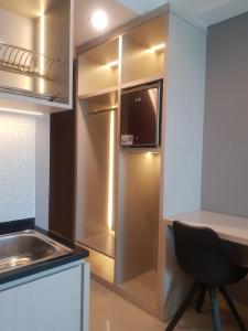 a kitchen with a refrigerator and a table and a chair at Apartemen Borneo Bay City (1 Bedroom Studio) in Klandasan Kecil
