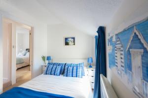 a bedroom with a bed with blue and white pillows at Meledor in Marazion