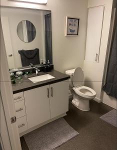 a bathroom with a toilet and a sink and a mirror at DTLA home away in Los Angeles