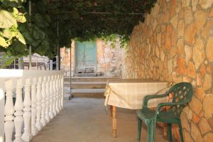 a table and chairs in front of a stone wall at Apartments by the sea Rukavac, Vis - 1154 in Vis