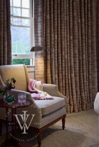 a living room with a chair and a window at Wickwood Inn in Saugatuck