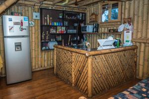 eine Küche mit einer Bar und einem Kühlschrank in einem Zimmer in der Unterkunft Villa Celina: La cabañita de Guadua in Santa Elena