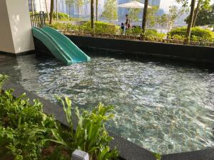 un tobogán de agua en una piscina en un edificio en Infini Suites@ Continew Residence KL, en Kuala Lumpur