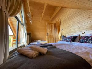 een slaapkamer met 2 bedden in een houten hut bij Domek drewniany w górach Jacuzzi & Balia - Osada Chełm in Stróża