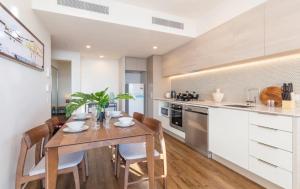 a kitchen with a wooden dining table and chairs at AirTrip Apartments at South Brisbane in Brisbane