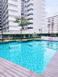 a large blue swimming pool in a city with buildings at Connected train 1 Bedroom (ABOVE MALL)7 in Kuala Lumpur