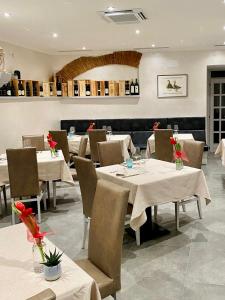 ein Restaurant mit Tischen und Stühlen mit Blumen darauf in der Unterkunft Antica locanda al Gelso in Monfalcone