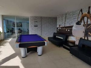 a living room with a ping pong table and couches at Hermoso apartamento. Cerca del mar. in Santa Marta