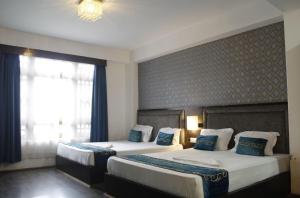 a bedroom with two beds with blue and white pillows at Palri Boutique Hotel in Gangtok