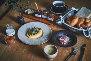 a wooden table with a plate of food and bread at Hotel Haus St Anton in Nozawa Onsen