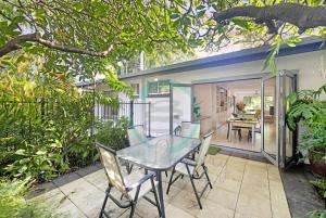a patio with a glass table and chairs at ZEN TREETOPS - Boutique 2-BR Apt w/ Private Pool in Larrakeyah