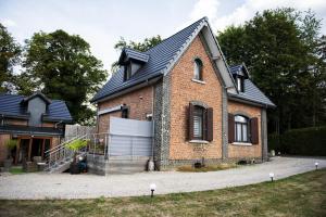 uma casa de tijolos com um telhado preto em La Sentinelle Gite em Spa