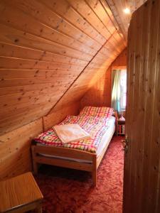 ein Schlafzimmer mit einem Bett in einem Holzzimmer in der Unterkunft Haus Fessel - Zeterklippe in Elend