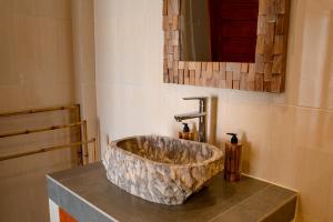 チャングーにあるThe Manggar Guesthouseのバスルーム(カウンターに大きな石のシンク付)