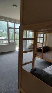 a room with bunk beds with a view of a mountain at La Heim Hostels in Manāli