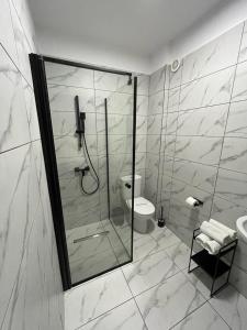 uma casa de banho com um chuveiro, um WC e um lavatório. em Hotel Rivoli em Bucareste