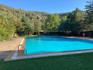una gran piscina azul en el césped en Cal Roig, en Margalef