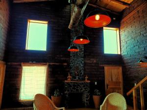 a room with red lights and a brick wall at Cabaña lejos de la ciudad Maxi in Acaxochitlán