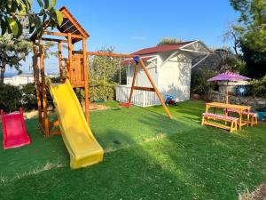 a playground with a slide in a yard at Katerina Charming Place in Agios Nikolaos
