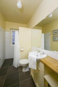 a bathroom with a white toilet and a sink at Loop Head Lightkeeper's House in Kilbaha