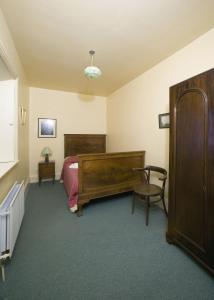sypialnia z łóżkiem i krzesłem w obiekcie Loop Head Lightkeeper's House w mieście Kilbaha