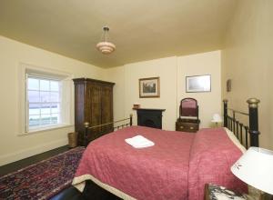 a bedroom with a bed with a red bedspread at Loop Head Lightkeeper's House in Kilbaha