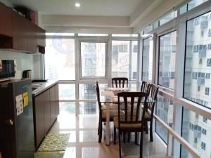 a dining room with a table and chairs in a kitchen at 2 BR loft-type condo Fort Victoria in Manila