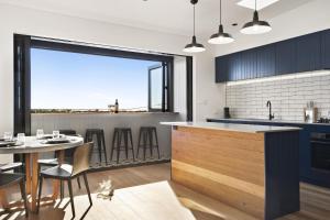 a kitchen with blue cabinets and a table and chairs at The Stables at the Hill in Newcastle