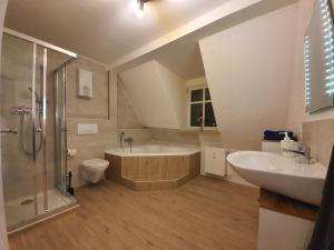 a bathroom with a tub and a toilet and a sink at Gemütliche Dachwohnung mit kleiner oder großer Dachterrasse nebeneinander in Wolmirstedt