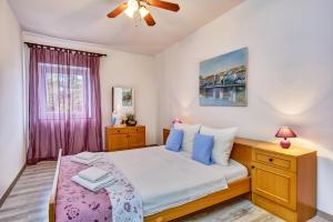 1 dormitorio con 1 cama y ventilador de techo en Holiday Home Lina Cipollina en Mali Lošinj