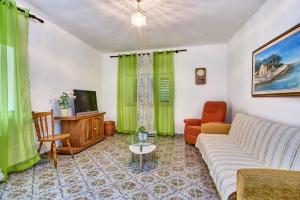 a living room with a couch and a tv at Holiday Home Lina Cipollina in Mali Lošinj