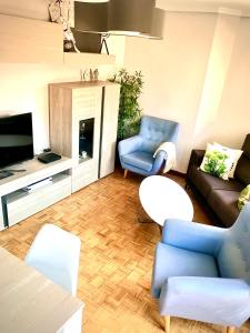 a living room with a couch and chairs and a tv at TUDELA CENTRO-Teatro Gaztambide-3 habitac. in Tudela