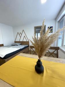 a room with two beds and a table with a yellow table cloth at Apartments and rooms pri Bašlju in Cerkno