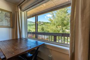 ein Fenster in einem Zimmer mit einem Holztisch und Aussicht in der Unterkunft Brettelberg Slopeside Condos F7 in Carbondale