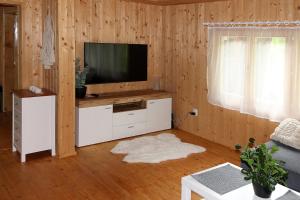 a living room with a flat screen tv on a wooden wall at Chata Brusno in Brusno
