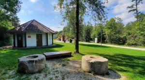 ein Park mit einer Bank, einem Baum und einem Gebäude in der Unterkunft Ferienwohnung Agerblick 3 Zimmer mit Küche, 83m2 in Lenzing